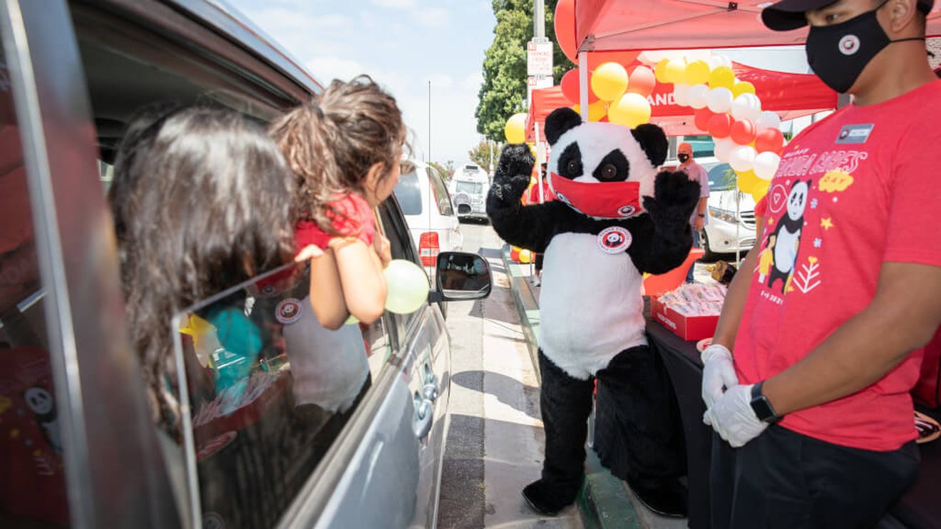 Car passengers watching Panda Cares mascot