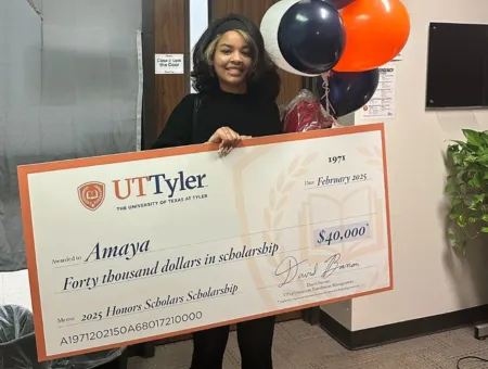 CIS student holding large check for college tuition